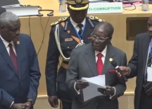 Zimbabwe President Robert Mugabe presents fundraising check of $1 million to the AU Summit