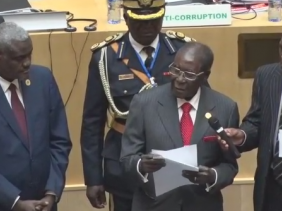 Zimbabwe President Robert Mugabe presents fundraising check of $1 million to the AU Summit
