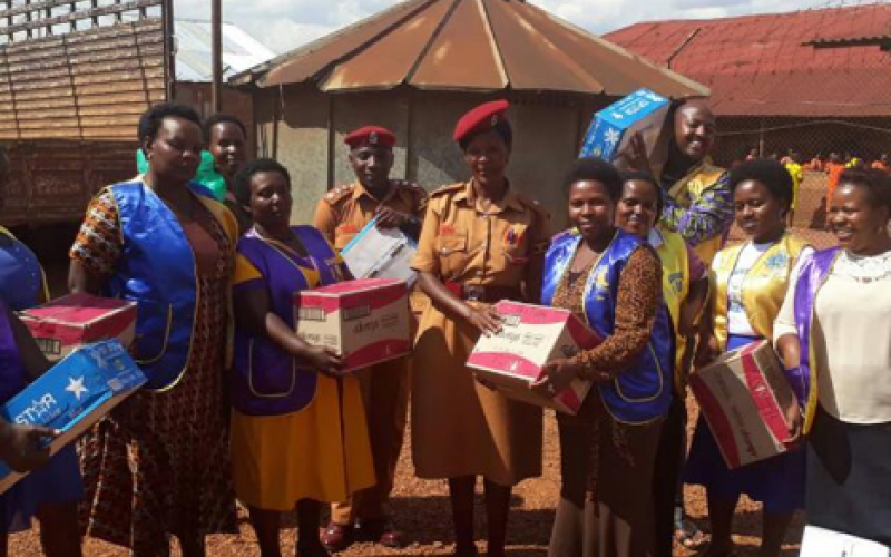 Chrispine Musimenta Rwaboona (on the left of the Police woman) delivering donations to inmates at Ndorwa Prison in Kabale