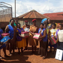 Chrispine Musimenta Rwaboona (on the left of the Police woman) delivering donations to inmates at Ndorwa Prison in Kabale